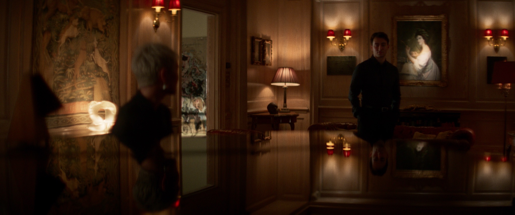 Matt stands across an opulent drawing room from Sarah and Ed in three