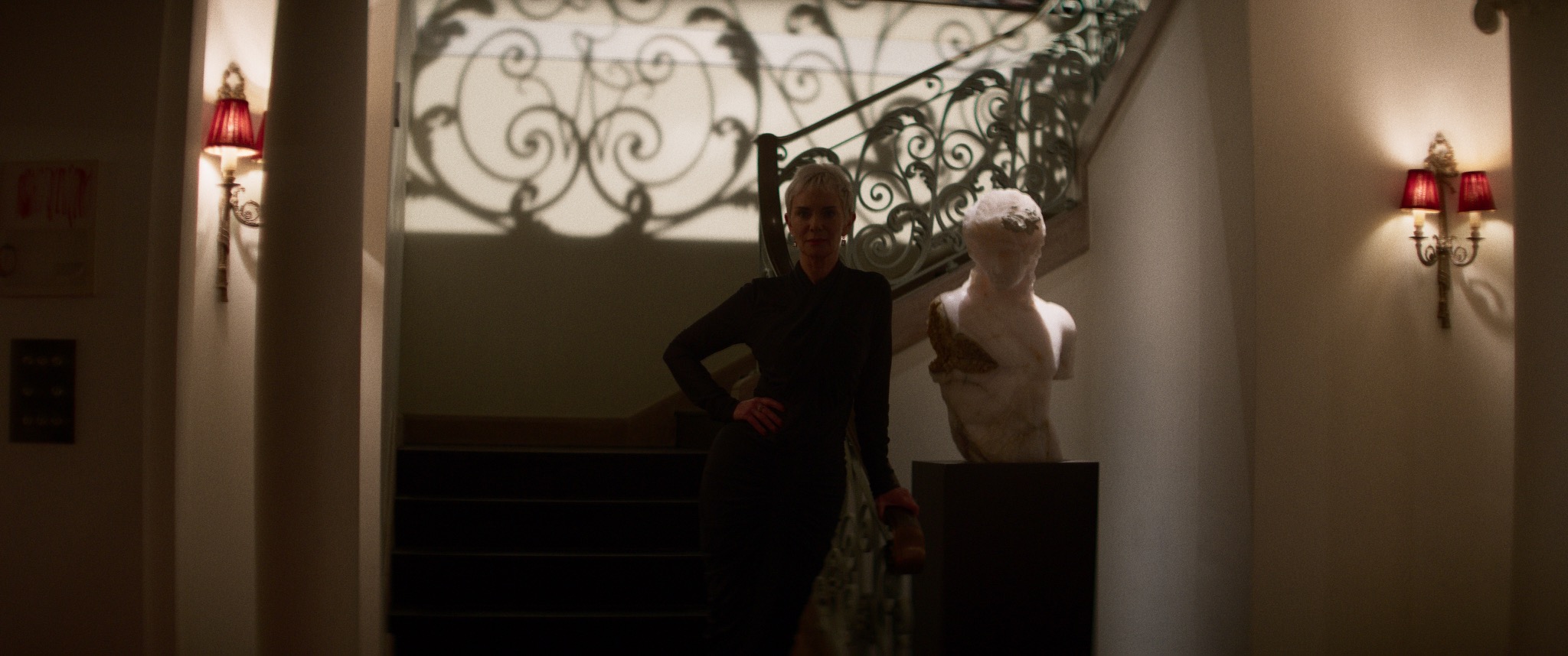 Victoria Hamilton as Sarah standing at the foot of an ornate staircase